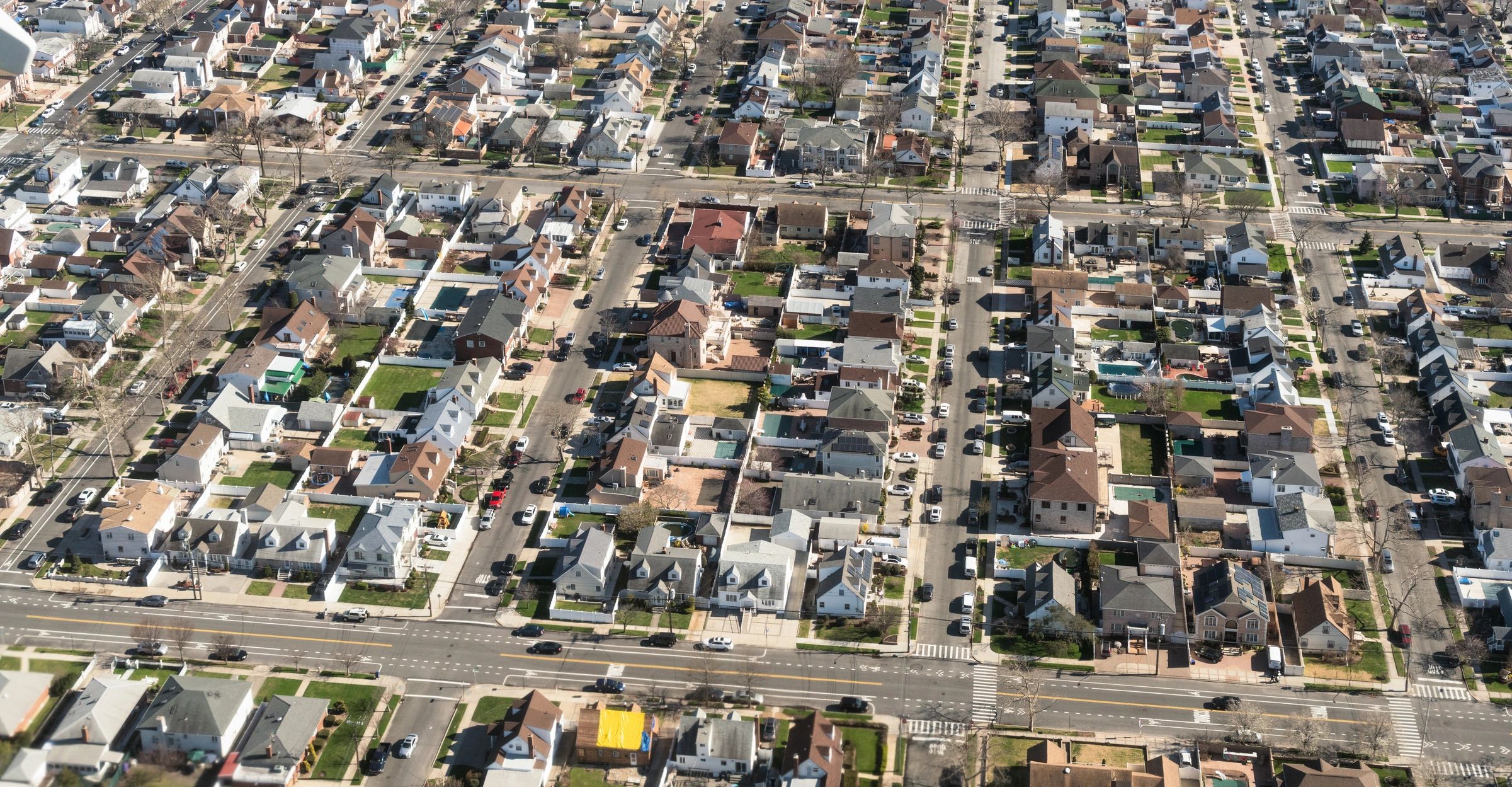 An aerial view of suburban detached houses and streets in New York City.